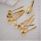 Luxury gold sunflower dessert spoon set on marble background