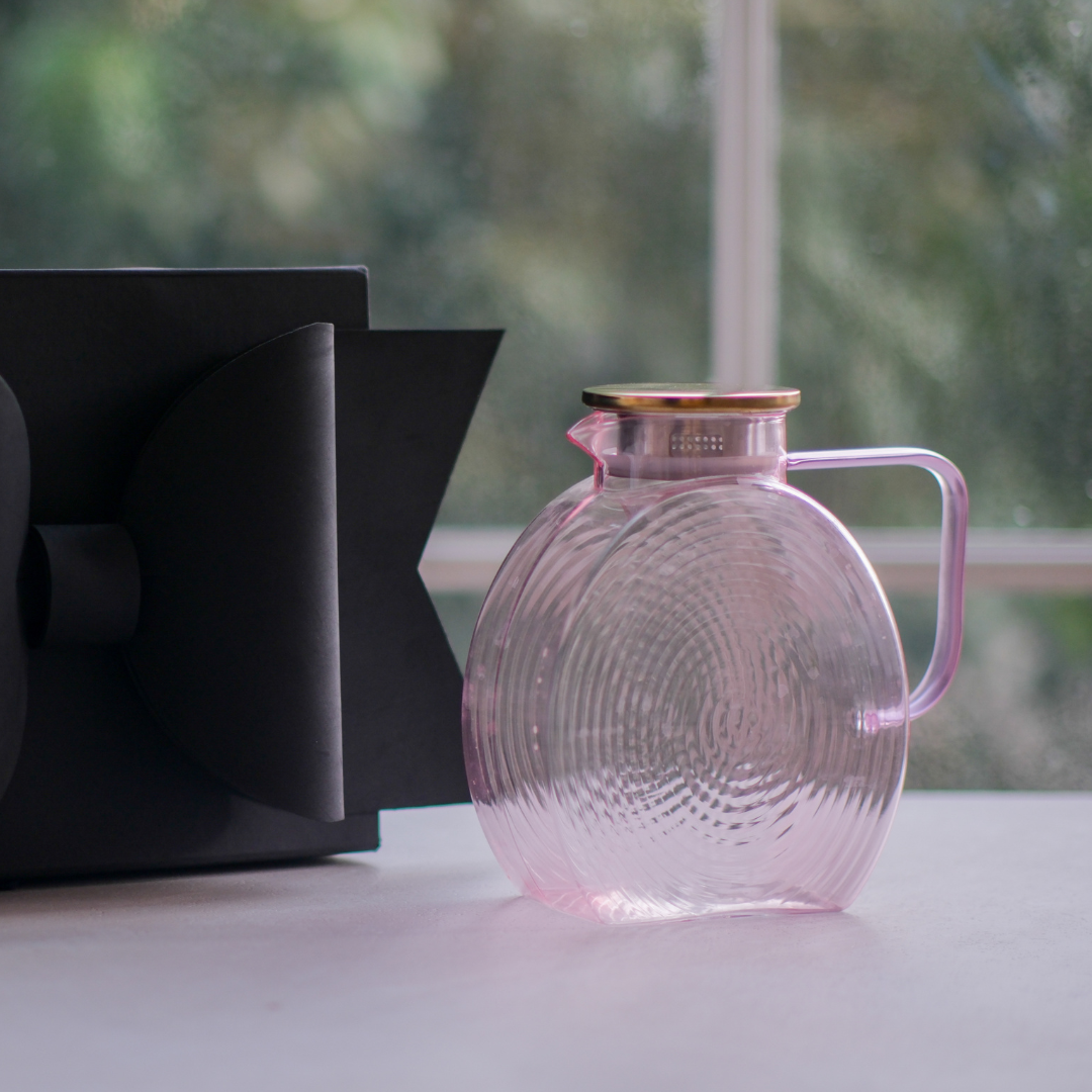 Textured pink glass jug with concentric ribbed design, gold lid and matching handle