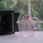 Textured pink glass jug with concentric ribbed design, gold lid and matching handle