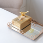 Luxury metallic tissue box with decorative bird accent in gold