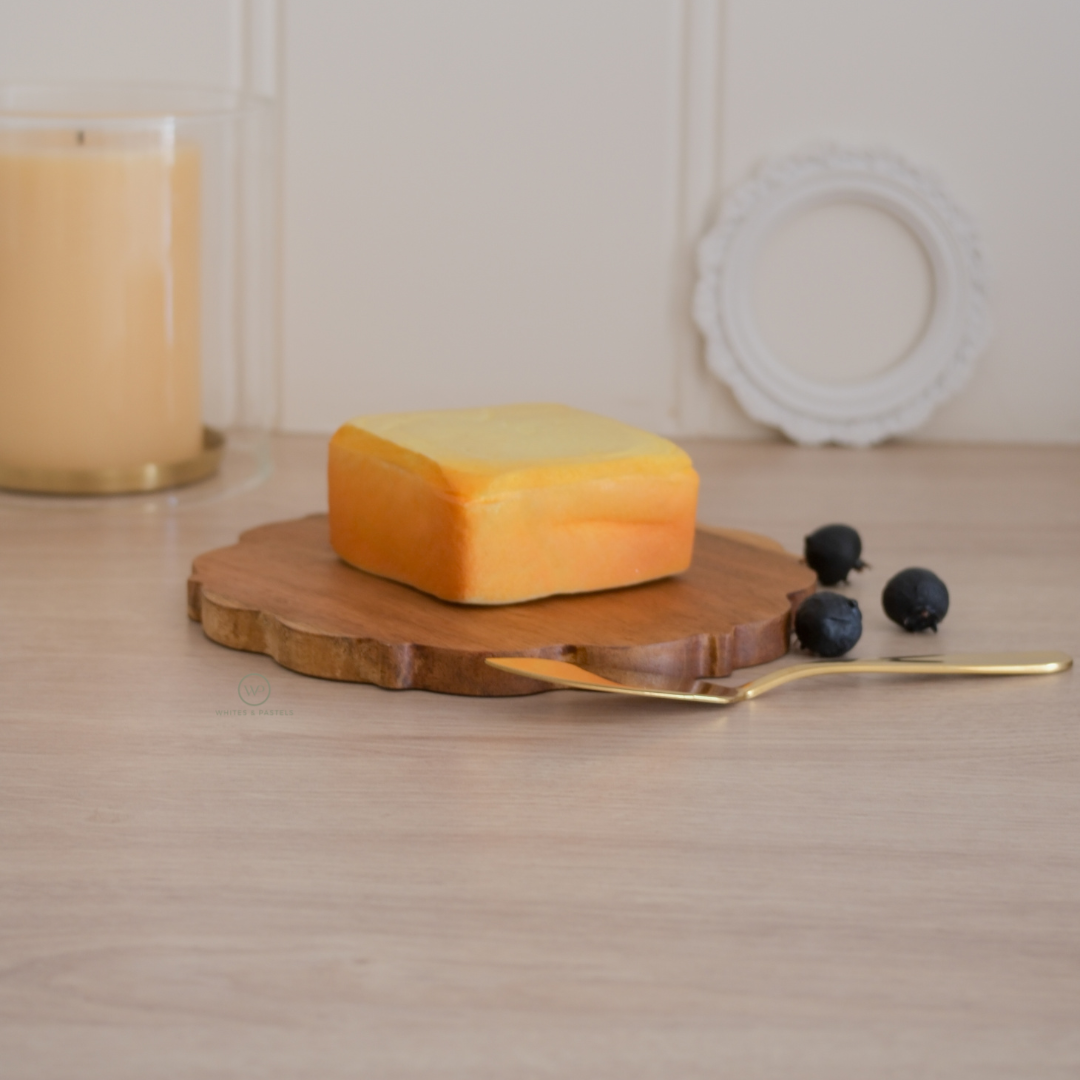 Wooden cheese board paired with an elegant gold butter knife