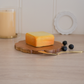 Wooden cheese board paired with an elegant gold butter knife
