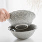 European embossed grey ceramic serving bowl with a floral pattern.