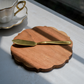 Scalloped edge charcuterie board placed on table with tea cup