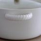 White ceramic casserole pot with dual side handles and glass lid for serving and cooking